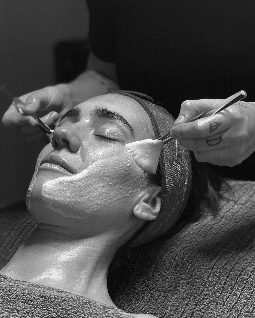 Svartvitt foto på Rosanna som njuter under skräddarsydd ansiktsbehandling hos A.N ESTETIK